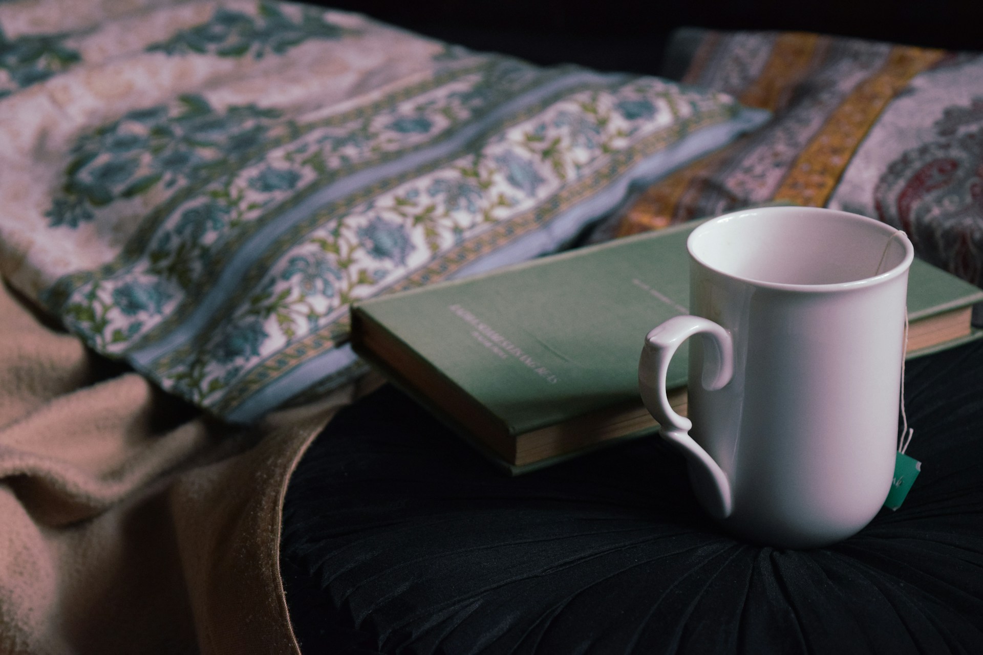 A cozy bed setup with tea and a book